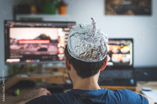 фотографія Conspiracy theory concept: young man is wearing aluminum head, sitting in front