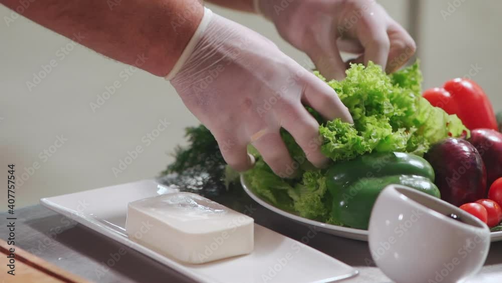 close up of chef cook hand in medical gloves take lettuce for prepare salad close up of chef cook hand in medical gloves take lettuce for prepare salad