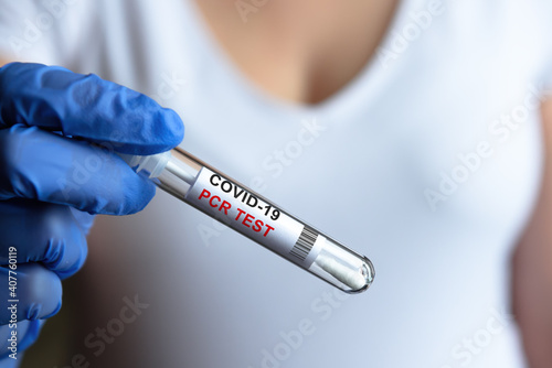 Coronavirus PCR test tube in doctor hand, tube to COVID-19 testing close-up