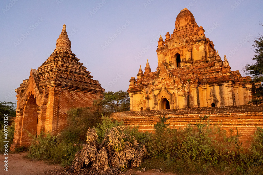 SUNSET, TEMPLES OF BAGAN, MYANMAR - 28 November 2017: Individual temple including front wall and west gate in warm evening light. SUNSET, TEMPLES OF BAGAN, MYANMAR - 28 November 2017: Individual temple including front wall and west gate in warm evening light.