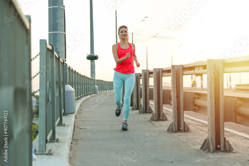 young sport woman is jogging and doing sport outdoors at sunset © Петр Смагин