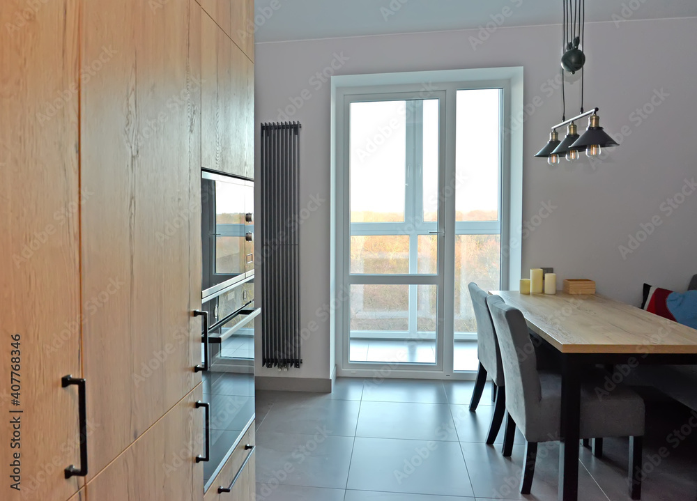 Fototapeta premium Fragment of the kitchen with access to the loggia. Modern minimalism