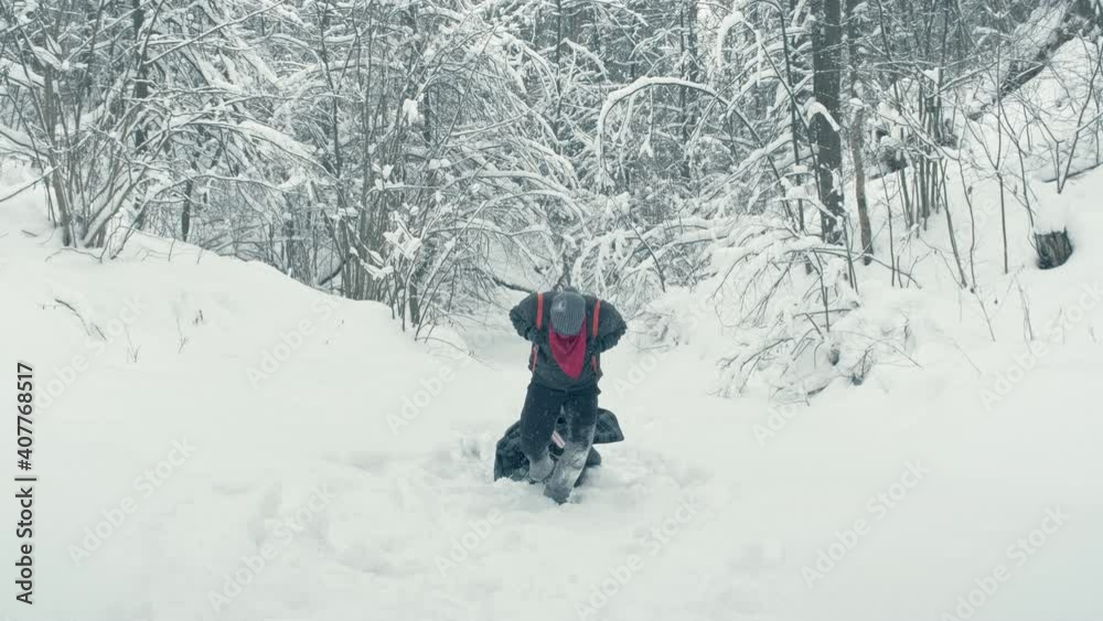 Man wearing a red bandana and black glasses drags a makeshift stretcher carrying a wounded man through a snowy area. Concept of rescue and survival Man wearing a red bandana and black glasses drags a makeshift stretcher carrying a wounded man through a snowy area. Concept of rescue and survival