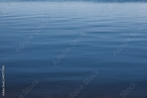 calm water surface with a perspective in the distance on a deep lake with contrast