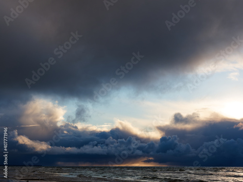 Heavy blue clouds over the sea at sunset. Weather forecast. Dramatic sky.