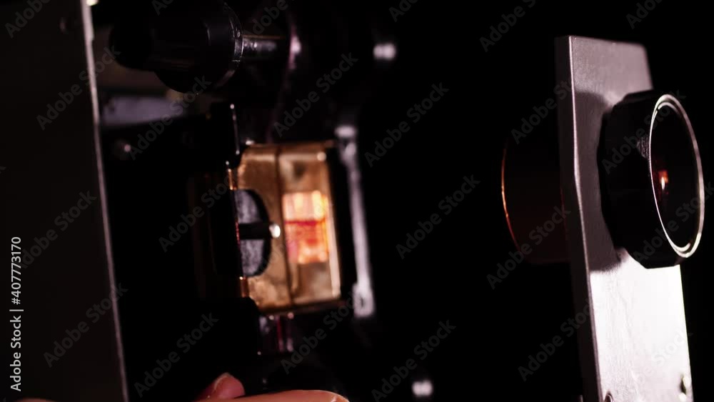 Macro view of vintage slide projector and fingers that are spinning a