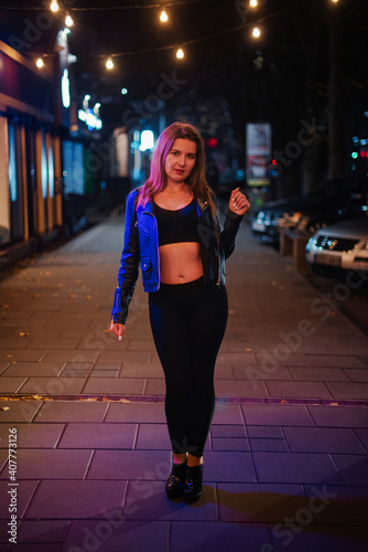 Girl in neon color walking in the night city