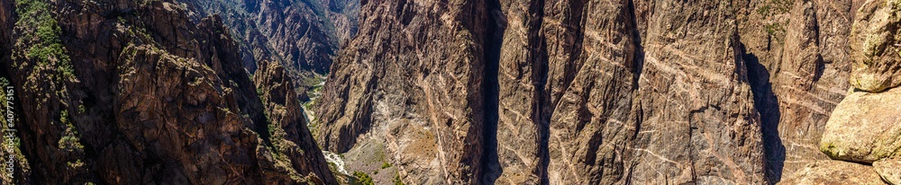 Panorama shot of gunnison river and rocky painted wall in black canyon of gunnison at sunny day in america