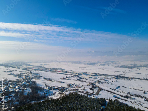 view of snowy fields from hill with drone
