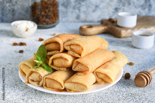 Thin spring rolls on a light concrete background. Platbands. National, traditional dish of Belarus and Ukraine. Pancakes