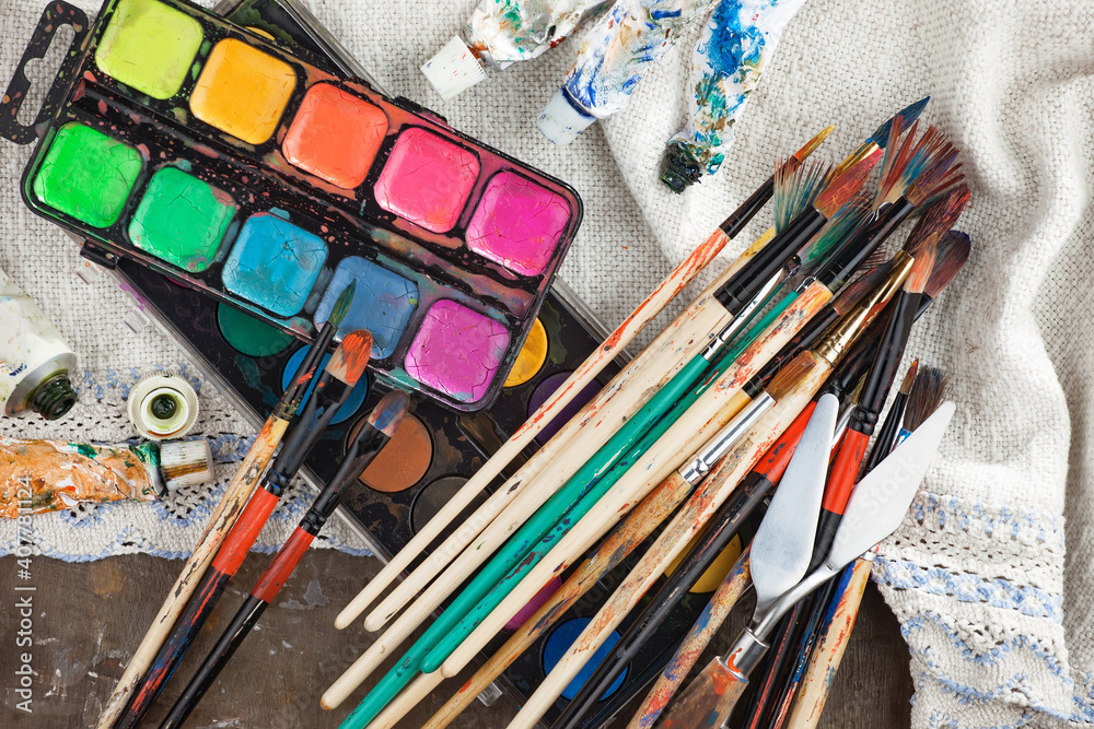 Obraz premium Brushes and paints for painting on an old background.