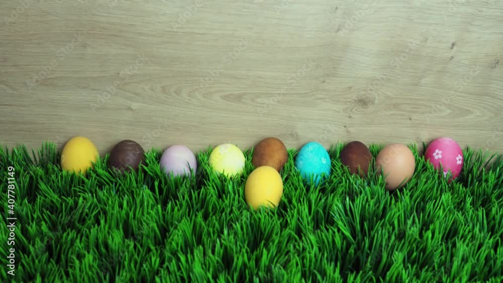 Happy Easter holiday concept stop motion animation. Colorful eggs appear on grass. Space for creative and design, copy space, top view Happy Easter holiday concept stop motion animation. Colorful eggs appear on grass. Space for creative and design, copy space, top view