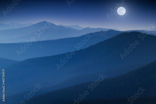 Fotografie, Obraz Bright Full  Moon Rises Over Hazy Colorado Rocky Mountain Range
