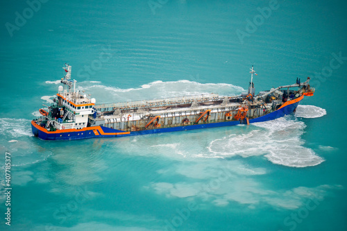 Suction Dredger Emptying Sluices, Spoiling Water of Gulf with mud Spot, Pollution, brown Muddy water - aerial shot photo