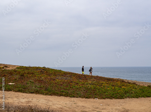 People walking alone in cliff along the shore and ocean, in costa vicentina, alentejo, portugal	
