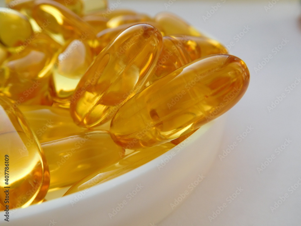 cod liver oil capsules close up on blurred white background cod liver oil capsules close up on blurred white background