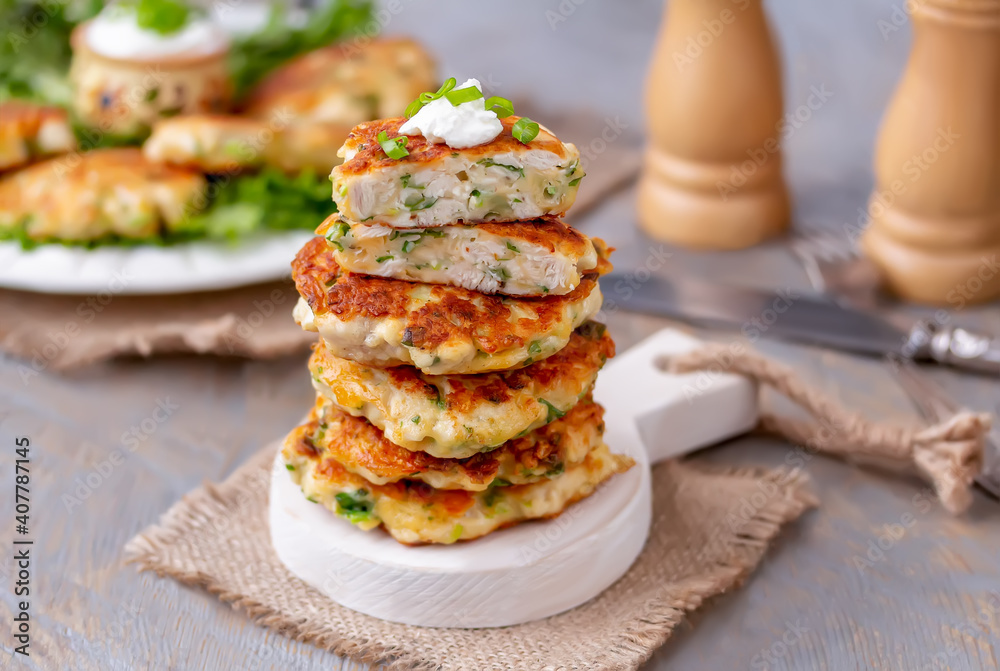 Stack of chicken patties with cheese and spring onion. Wooden background, selective focus. Stack of chicken patties with cheese and spring onion. Wooden background, selective focus.