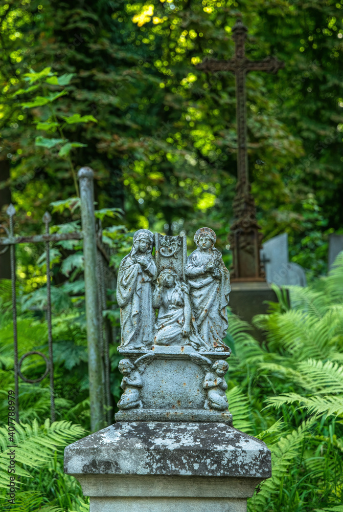 Lviv, Ukraine - July 12, 2019: Ancient gothic Lychakiv cemetery in Lviv, Ukraine. Ancient stone crypts, tombs and gravestones against the backdrop of overgrown green trees and herbs. Famous landmark Lviv, Ukraine - July 12, 2019: Ancient gothic Lychakiv cemetery in Lviv, Ukraine. Ancient stone crypts, tombs and gravestones against the backdrop of overgrown green trees and herbs. Famous landmark