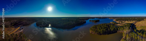 a stunning aerial panoramic shot of the still blue waters of Lake McIntosh at sunset with vast miles of lush green and autumn colored trees and blue sky at Lake McIntosh in Peachtree City, Georgia photo