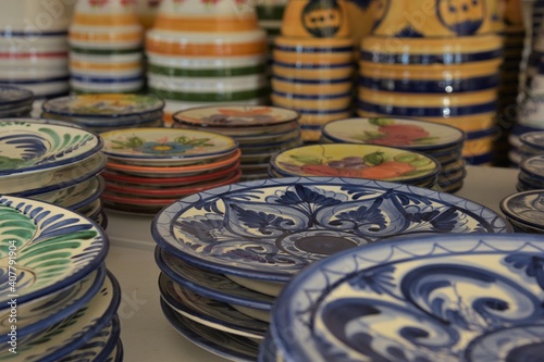 Stacks of multicolored Andalusian majolica ceramic plates and flower pots in a commercial display in La Rambla, Spain