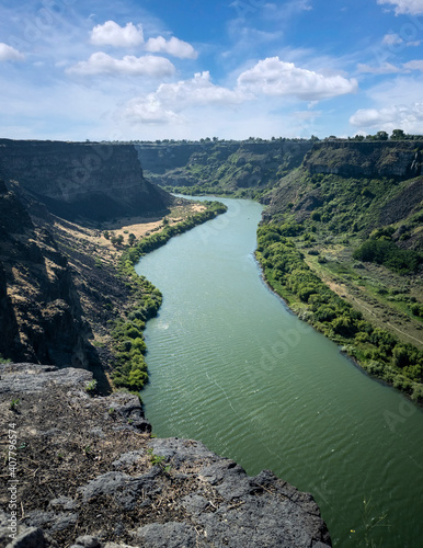 Winding Snake River flowing thru the pacific northwest in the summertime on a partly cloudy day