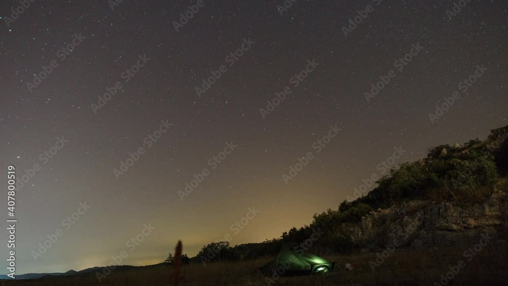 Moving stars and clouds with big dipper over tent in croatian landscape at night