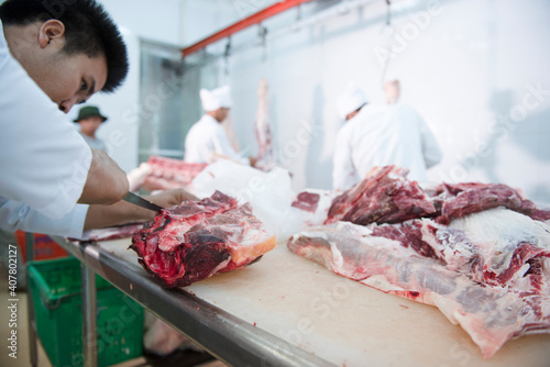 A meat seller cuts fresh meat in a Japanese ham and wagyu beef factory