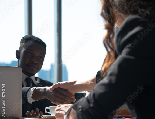 Close up hands shake of African businessman with Caucasian women.