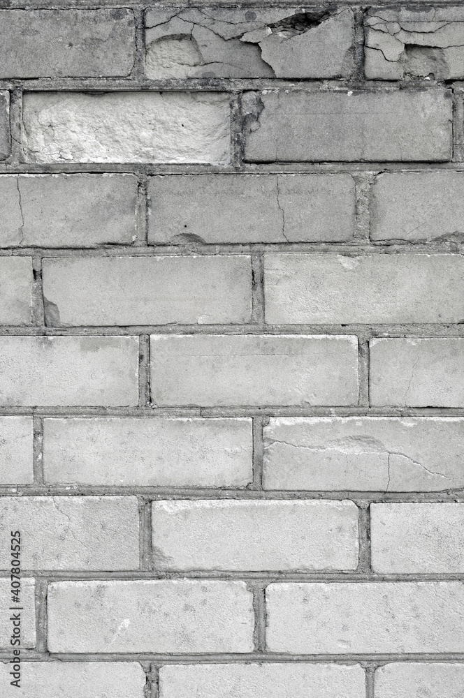 Obraz premium White light grey old aged weathered fine brick wall texture, grungy damaged calcium silicate bricks pattern detail background macro closeup, large detailed textured vertical grunge ruined brickwork