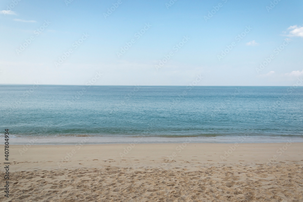 View of the sandy beach, summer sea and blue sky.