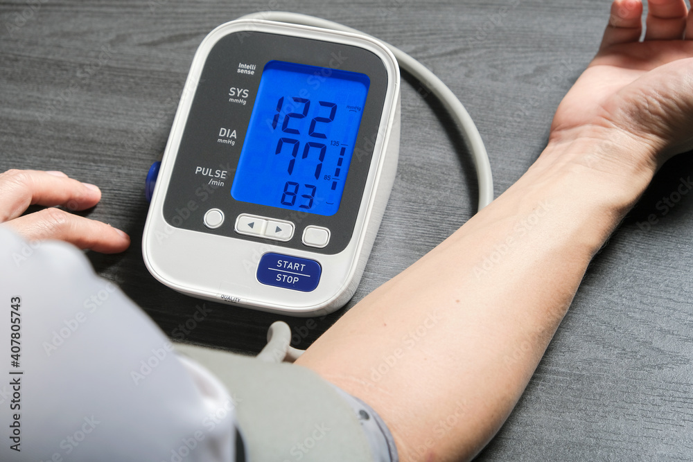 Man check blood pressure monitor and heart rate monitor with digital pressure gauge. Health care and Medical concept Man check blood pressure monitor and heart rate monitor with digital pressure gauge. Health care and Medical concept