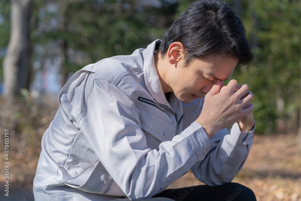 落ち込む　建築着を着たアジア人男性