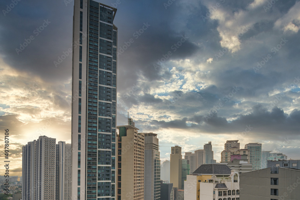 Office building and apartment in Makati City under dramatic cloudy sky