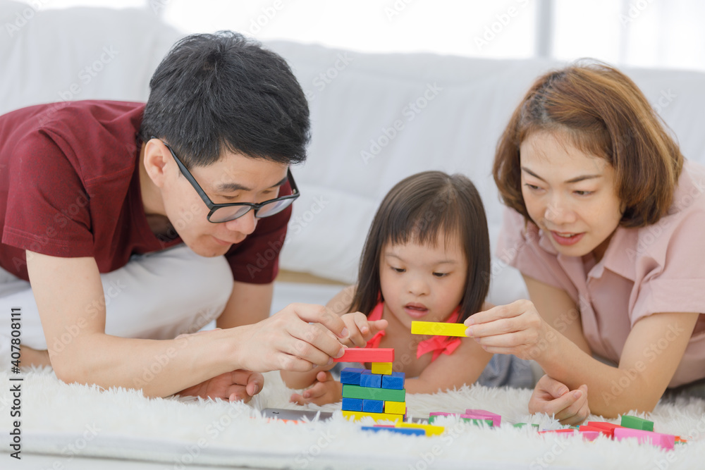 Parent and daughter playing playing a colorful wood block toy in the bedroom at home.leisure activity togetherness.