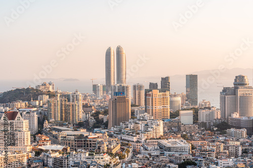 Xiamen city skyline with modern buildings, twin towers, old town and sea at dusk