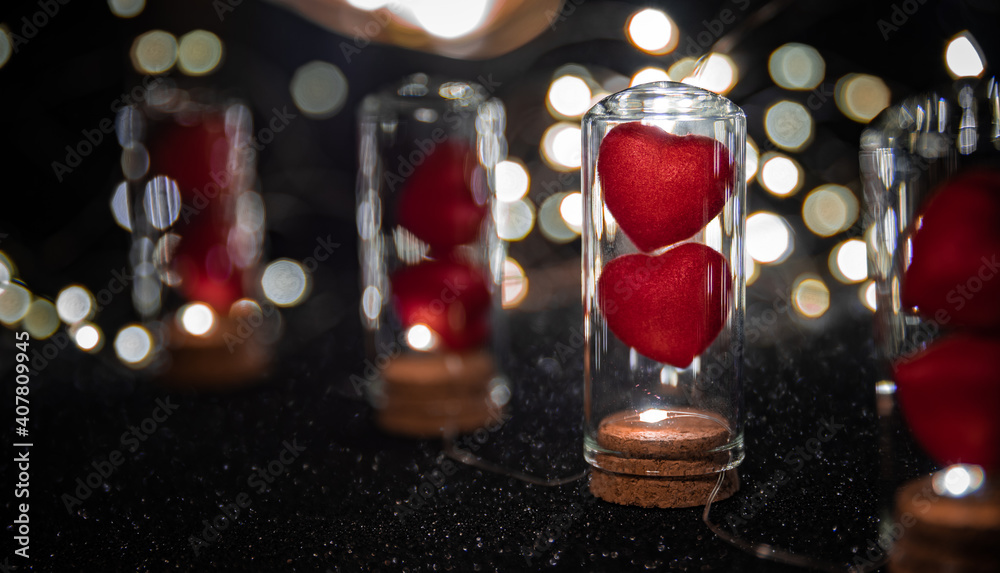 Two Red Hearts in Cork Glass Bottles With Led Lights and black Luminous copy space Background for Valentine's Day