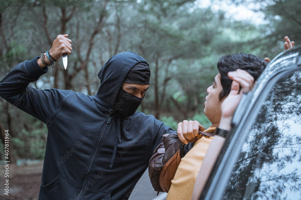 robber in a mask use a sharp weapon want to kill the victim when getting out of the car in the parking lot robber in a mask use a sharp weapon want to kill the victim when getting out of the car in the parking lot