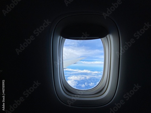 Blue sky and clouds outside airplane window.