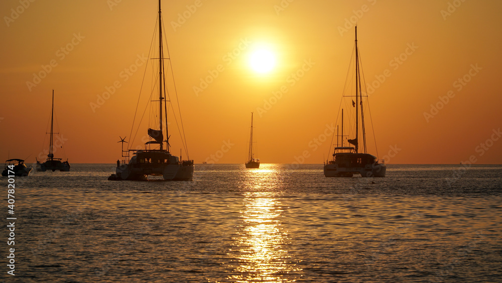 Orange tropical sunset on Nai Harn beach on Phuket in Thailand in January high season