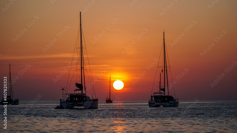 Orange tropical sunset on Nai Harn beach on Phuket in Thailand in January high season