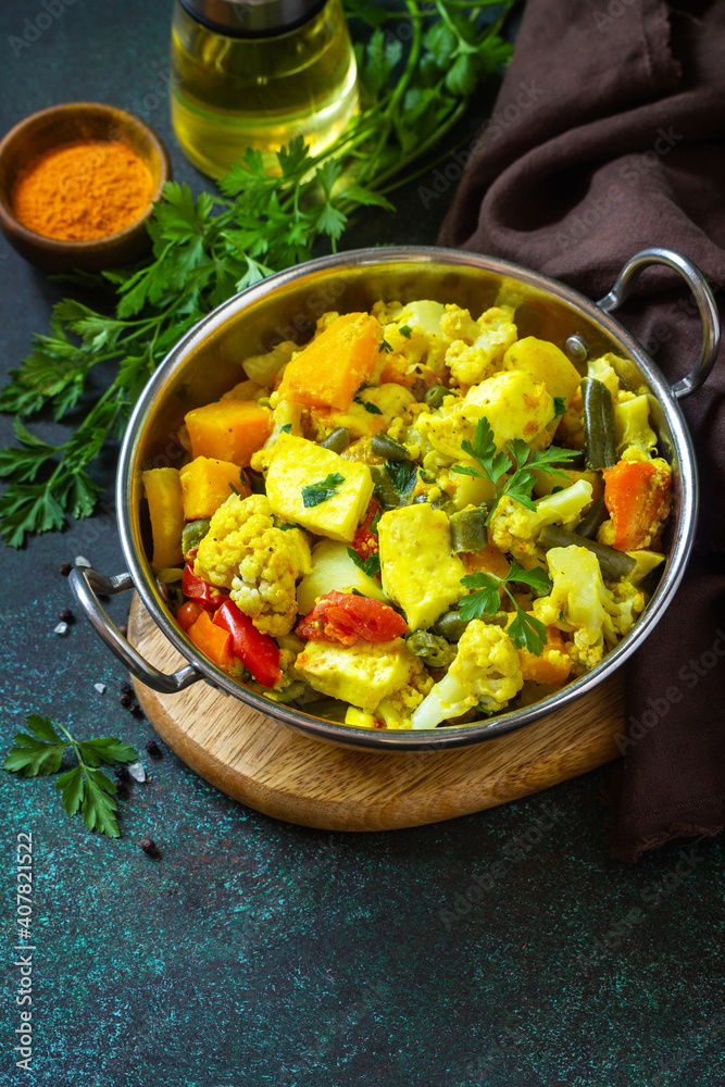 Sabji, Stewed pumpkin with soft cheese and vegetables on a dark stone table. Traditional Indian food. Copy space. Sabji, Stewed pumpkin with soft cheese and vegetables on a dark stone table. Traditional Indian food. Copy space.