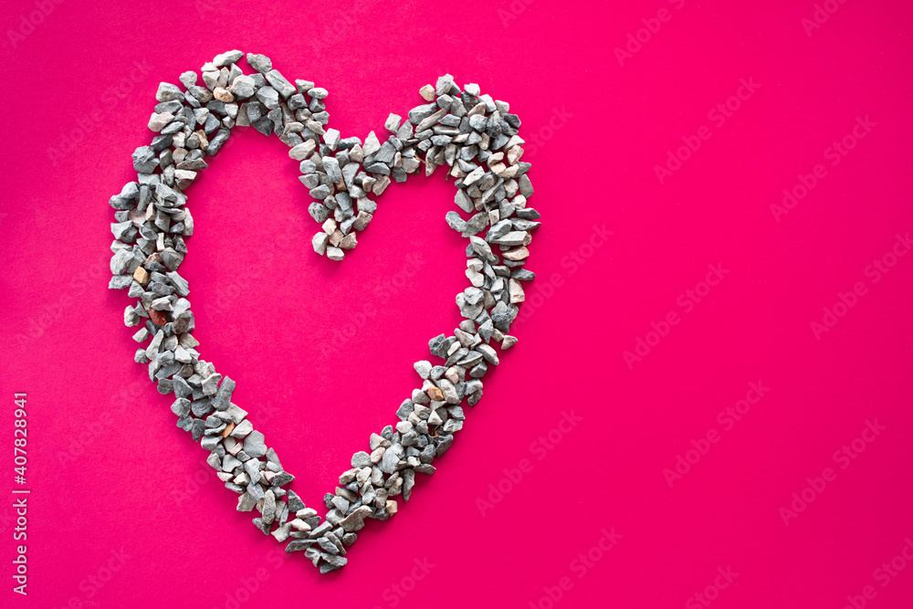 Heart symbol Made of small stones Or pebbles placed on a pink background. It is a concept of love day or Valentine's day. Take a top view and close-up
