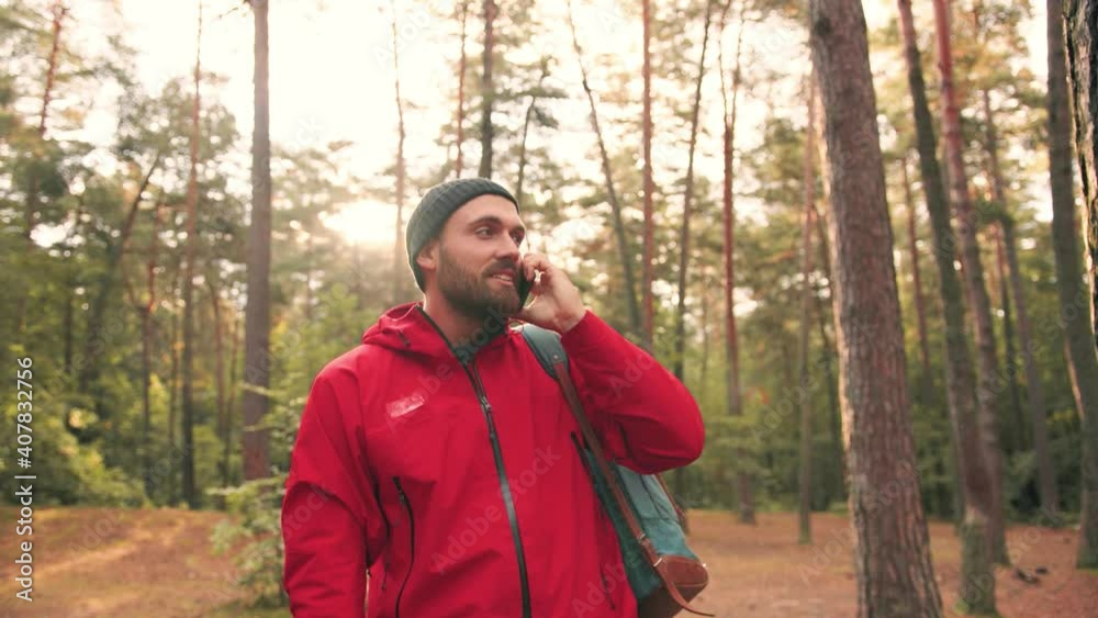 Young Caucasian man with travel backpack standing on meadow in woods holding out his hand with smartphone search of mobile network. Young Caucasian man with travel backpack standing on meadow in woods holding out his hand with smartphone search of mobile network.