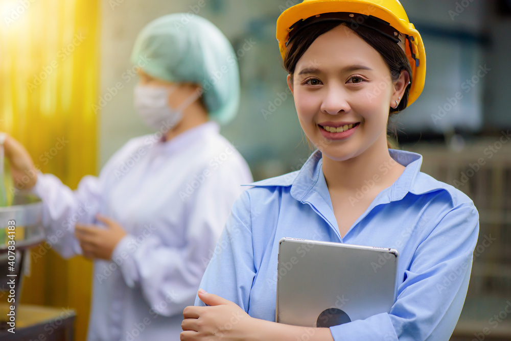 Confident Asian woman owner standing at goods warehouse store and check for control juice industrial process at factory. Teamwork at production line successful concept. Confident Asian woman owner standing at goods warehouse store and check for control juice industrial process at factory. Teamwork at production line successful concept.