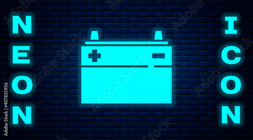 Glowing neon Car battery icon isolated on brick wall background. Accumulator battery energy power and electricity accumulator battery. Vector.