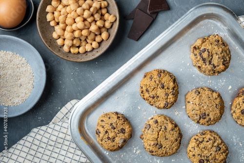 Horizontal composition of a baking tray with freshly baked chickpea cookies and dark chocolate chips