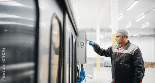 Fotografie Factory engineer man operating machine control panel in dairy milk production pl