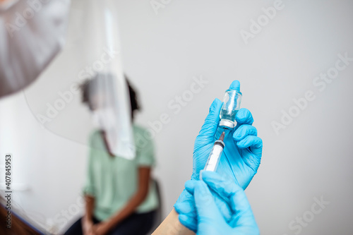 Doctor hands holding covid-19 vaccine preparing for vaccination of a patient. Coronavirus vaccination process. Medical doctor giving injection to make antibody for coronavirus