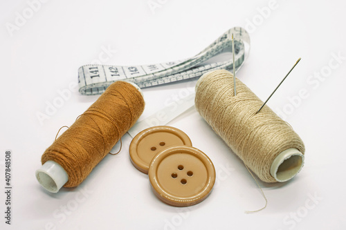 Sewing accessories. Threads, needles, tape measure, buttons, pins. Close-up. White background. Hobby. Needlework. Sewing
