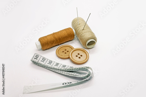 Sewing accessories. Threads, needles, tape measure, buttons, pins. Close-up. White background. Hobby. Needlework. Sewing